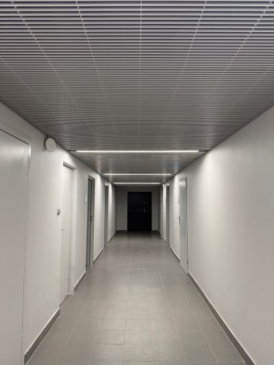 A clean, modern corridor ceiling, using Flash, Aluminium wedge wire panels.