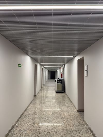A clean, modern corridor ceiling, using Flash, Aluminium wedge wire panels.